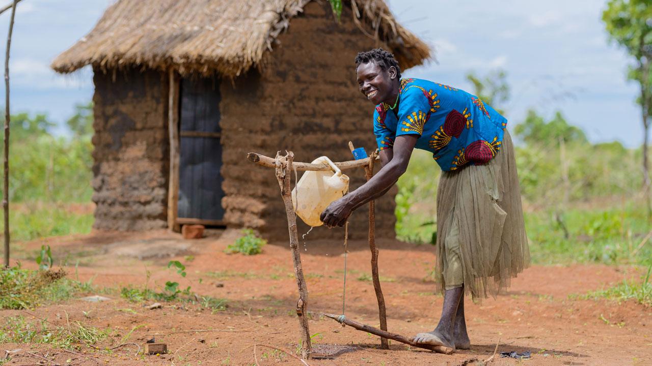 A woman washes her hands after using her household’s latrine in the Kitgum district of Uganda where a Tetra Tech-led water and sanitation project has increased access to latrines and handwashing stations